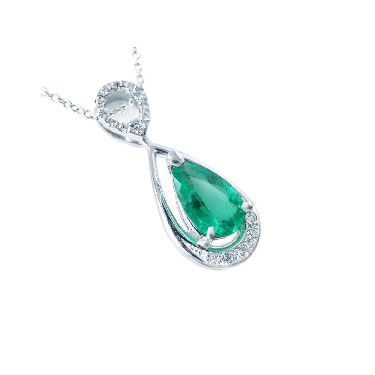 A 14k white gold necklace with a teardrop natural colombian emerald pendant on a white background.