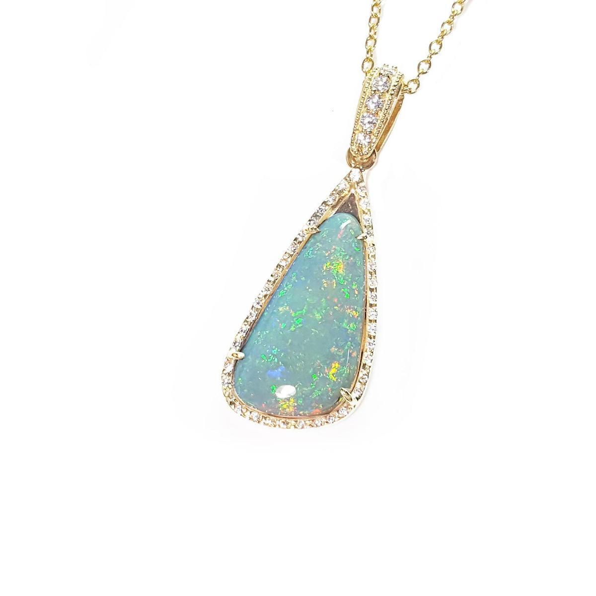 Opal pendant necklace on a gold chain left-side view with a white background