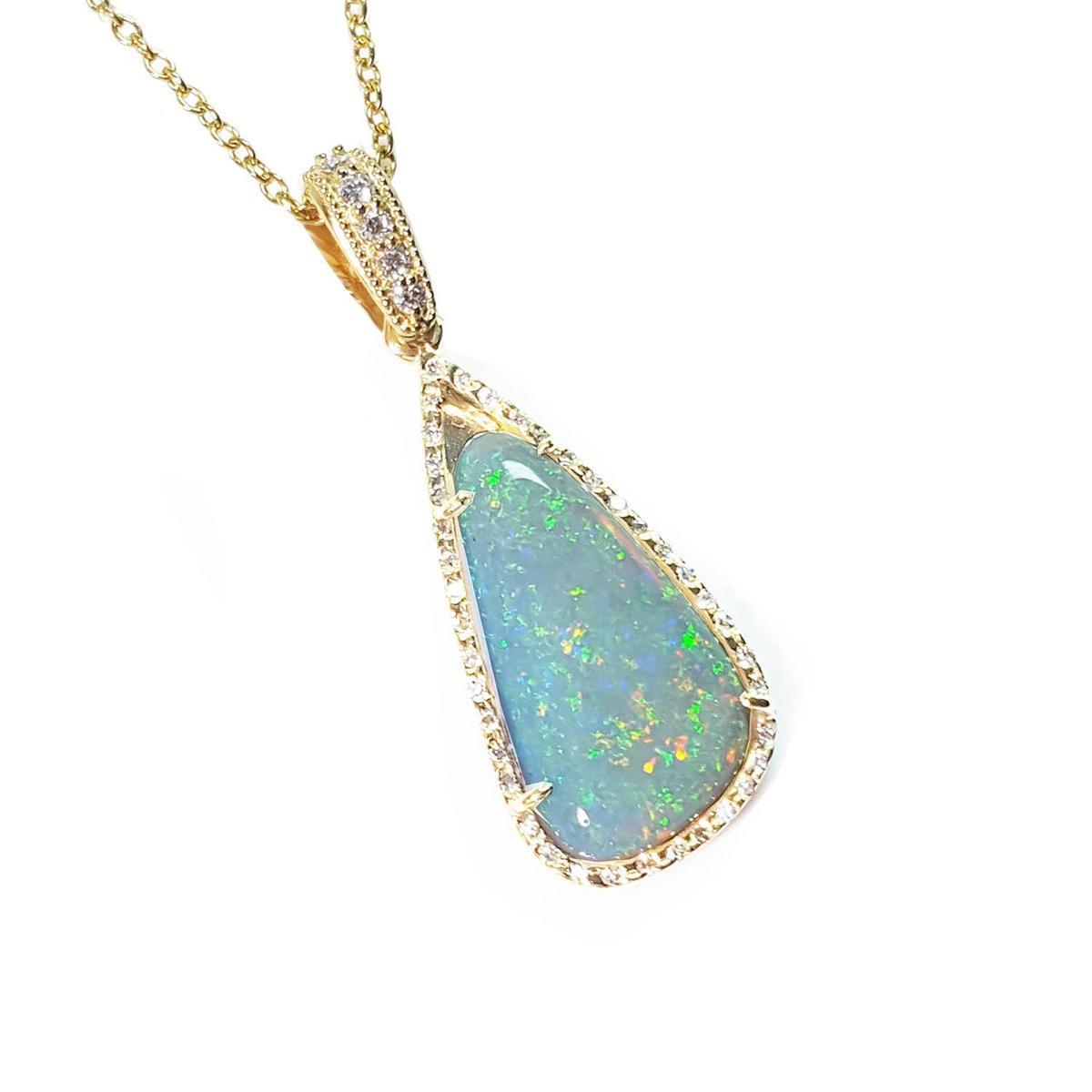 Opal pendant necklace with gold chain on a white background