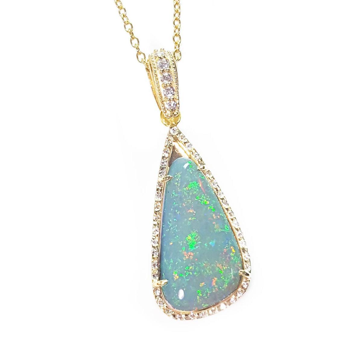 Opal pendant necklace with gold frame topside view on a white background