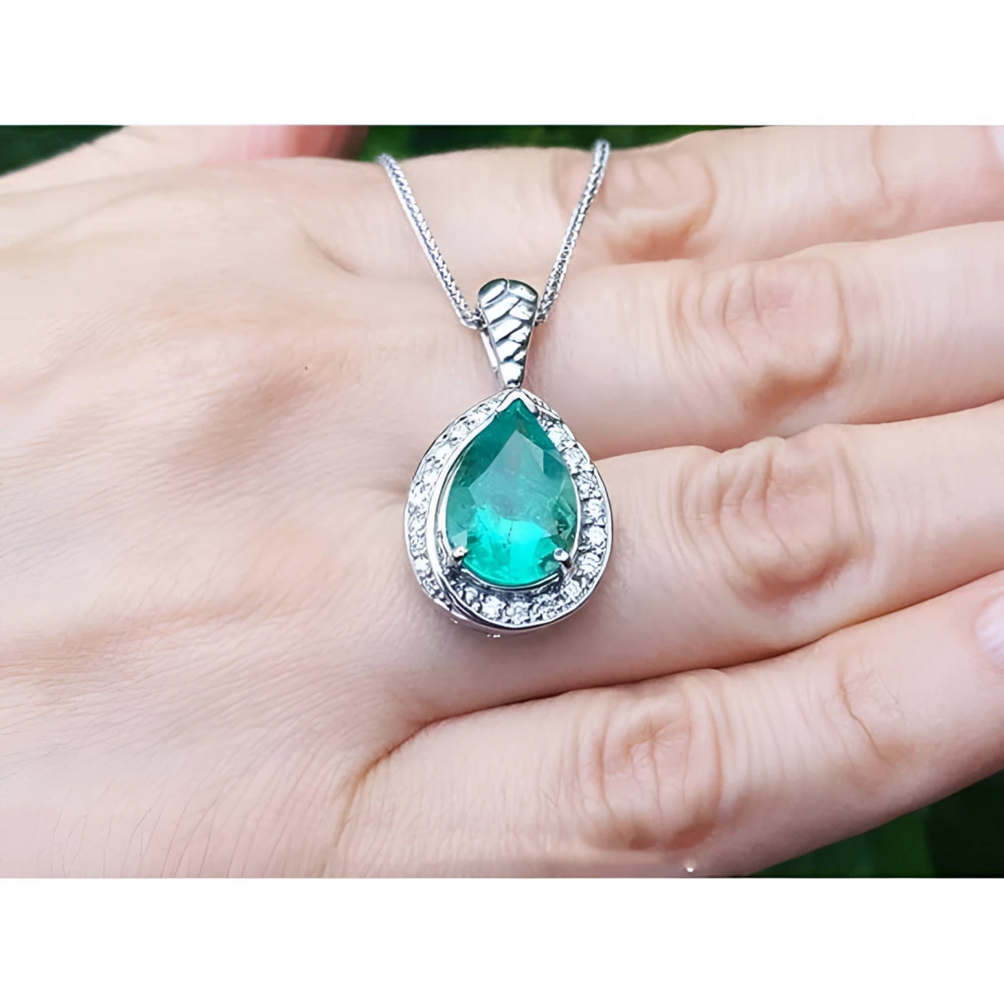 5.03 ct. pear-shaped natural emerald pendant with diamond halo on a 14K white gold chain.