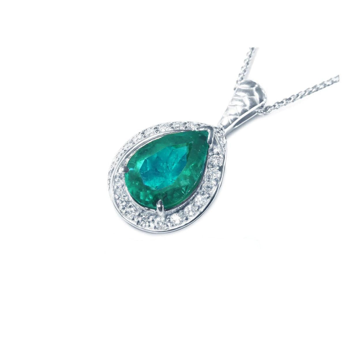 Teardrop-shaped emerald pendant with diamond accents on a left side position topside view