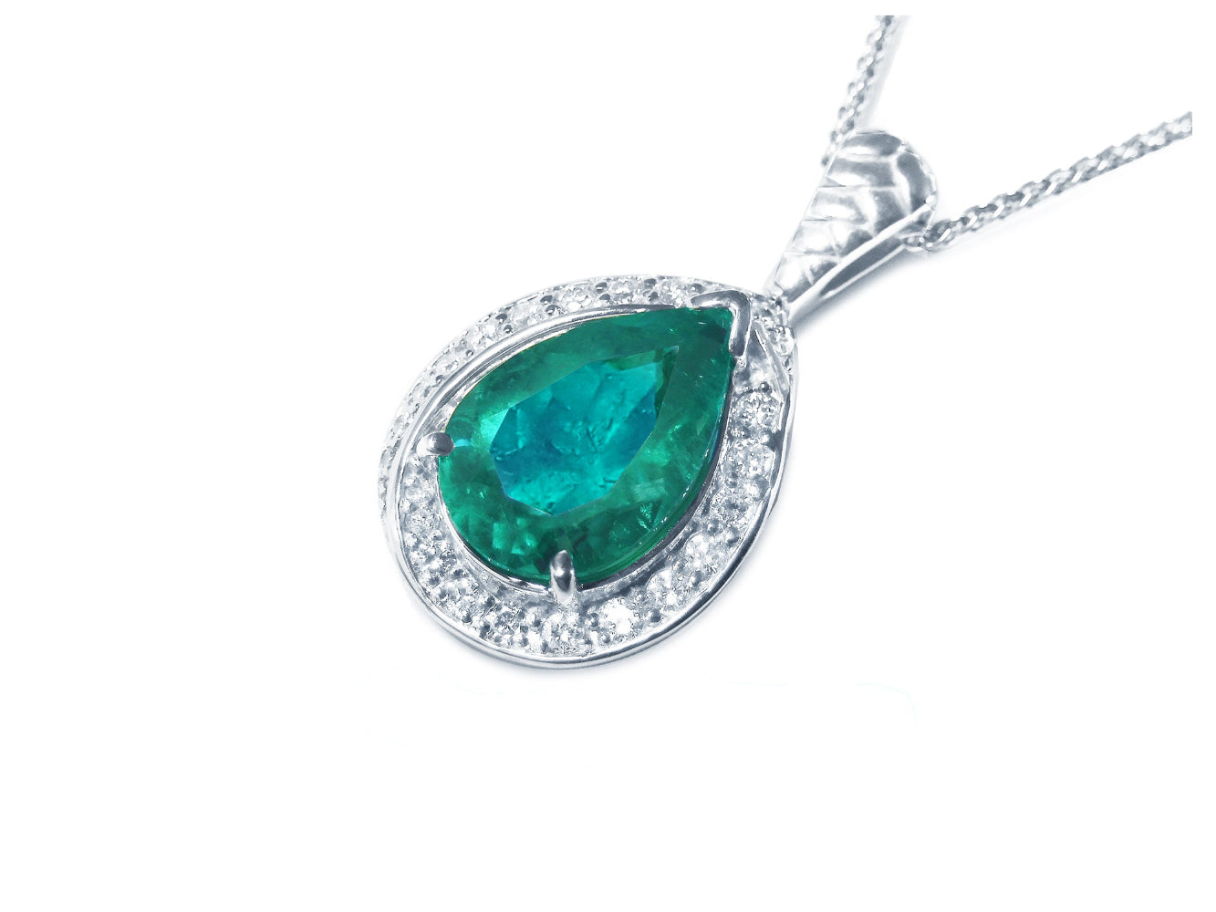 Teardrop-shaped emerald pendant with diamond accents on a left side position topside view