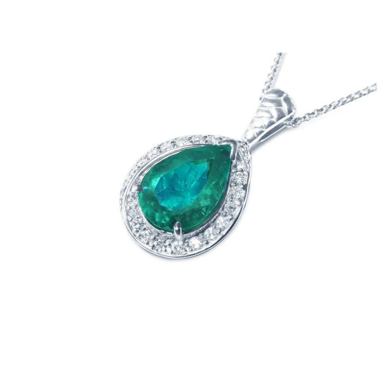 Teardrop-shaped emerald pendant with diamond accents on a left side position topside view