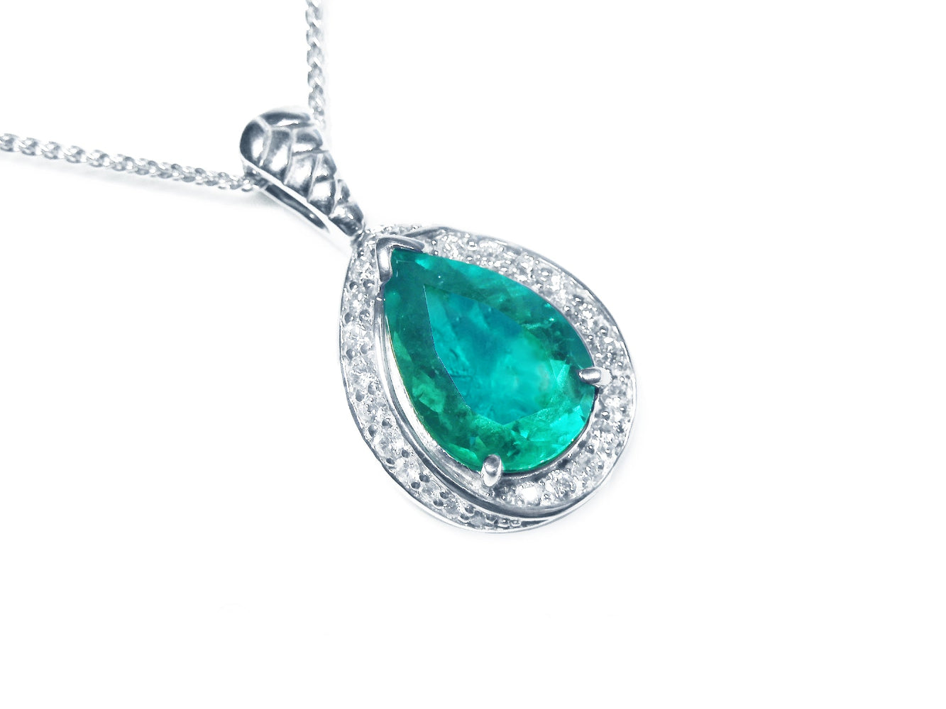 Teardrop-shaped emerald pendant with diamond accents in white gold topside profile