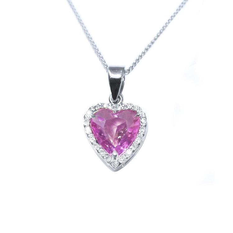 Heart-cut pink sapphire pendant with diamond halo in 18K white gold on a delicate chain.