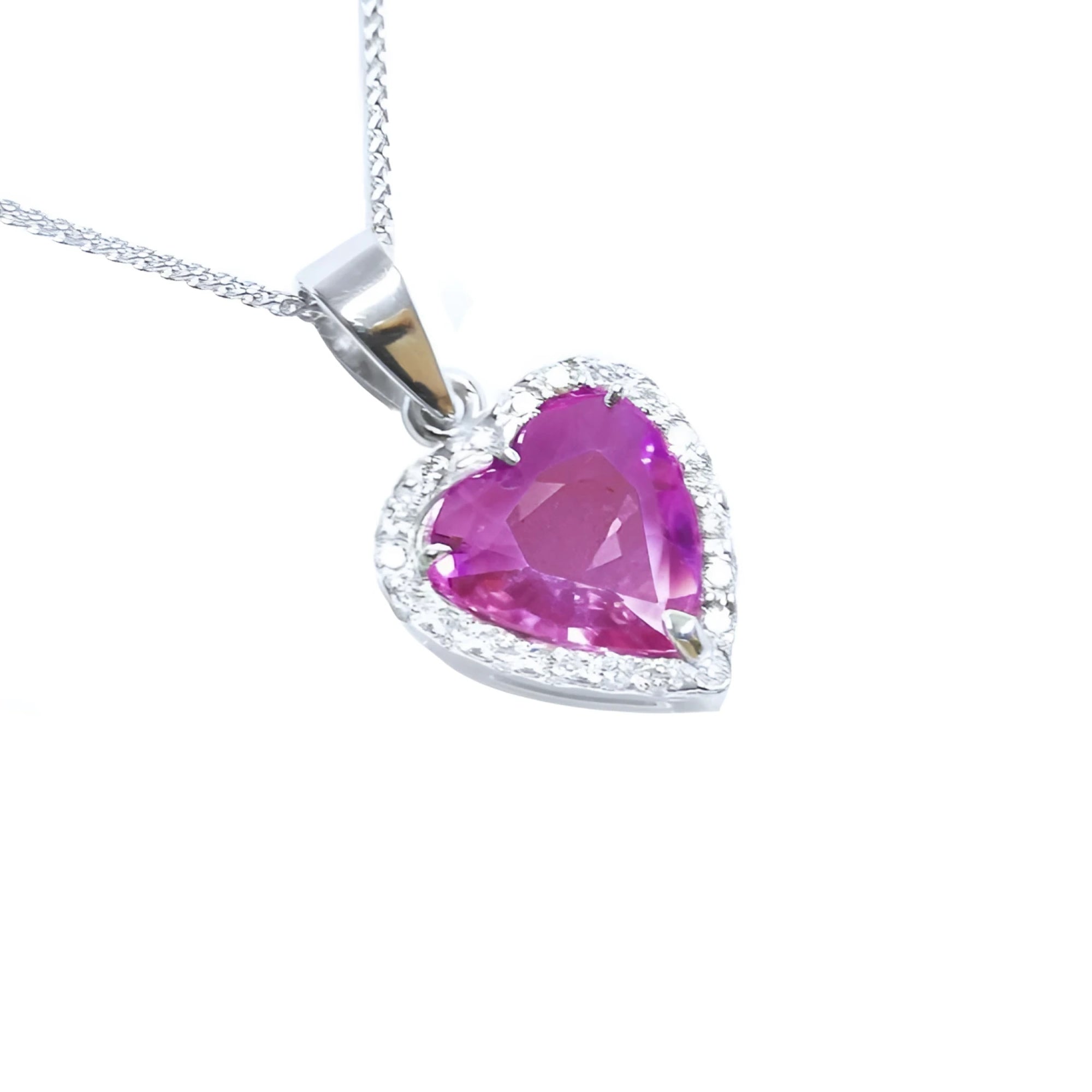 Natural pink sapphire heart pendant encircled by a halo of natural diamonds crafted in 18k white gold.