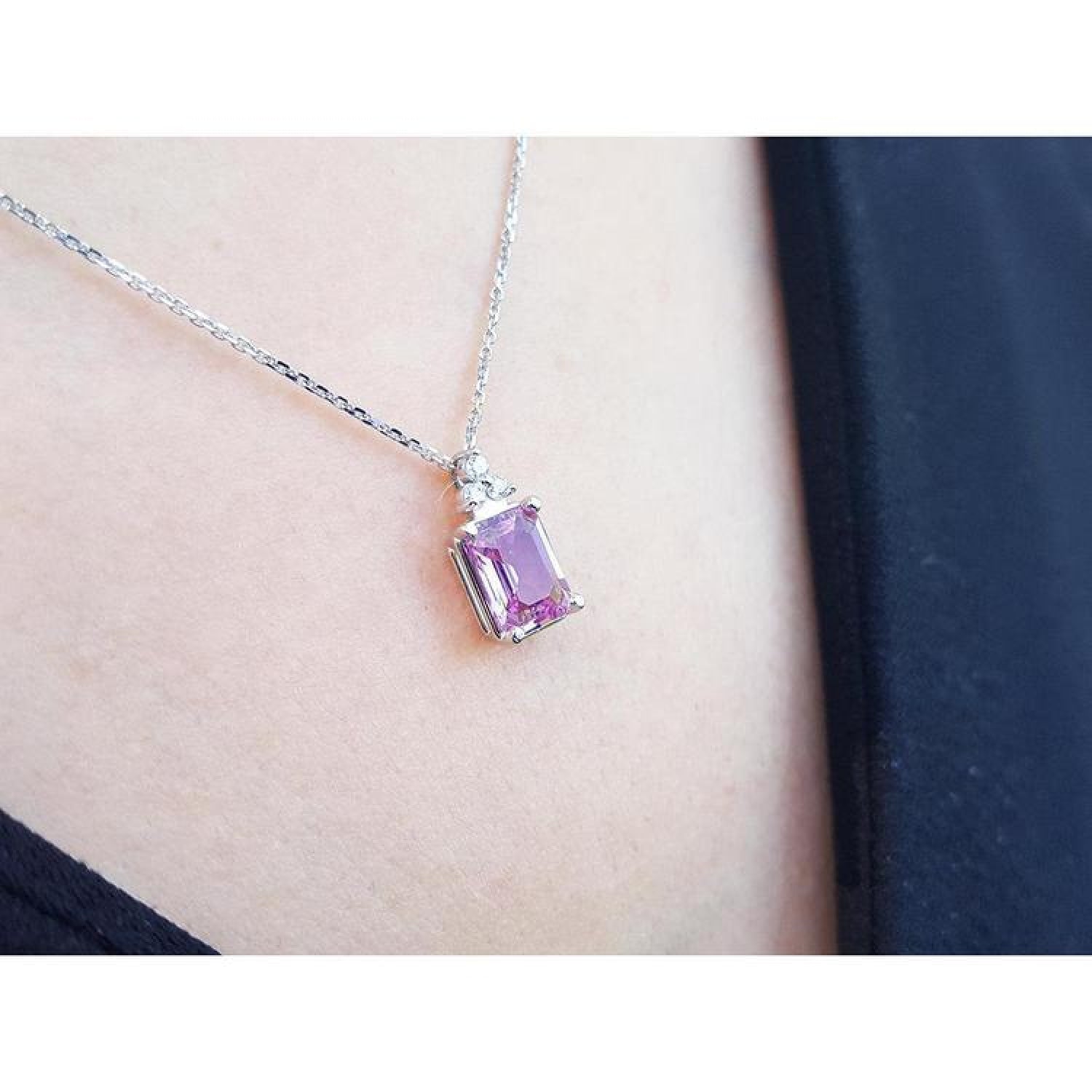 2.01 ct. natural pink sapphire emerald cut necklace in 14K white gold, worn on a person.