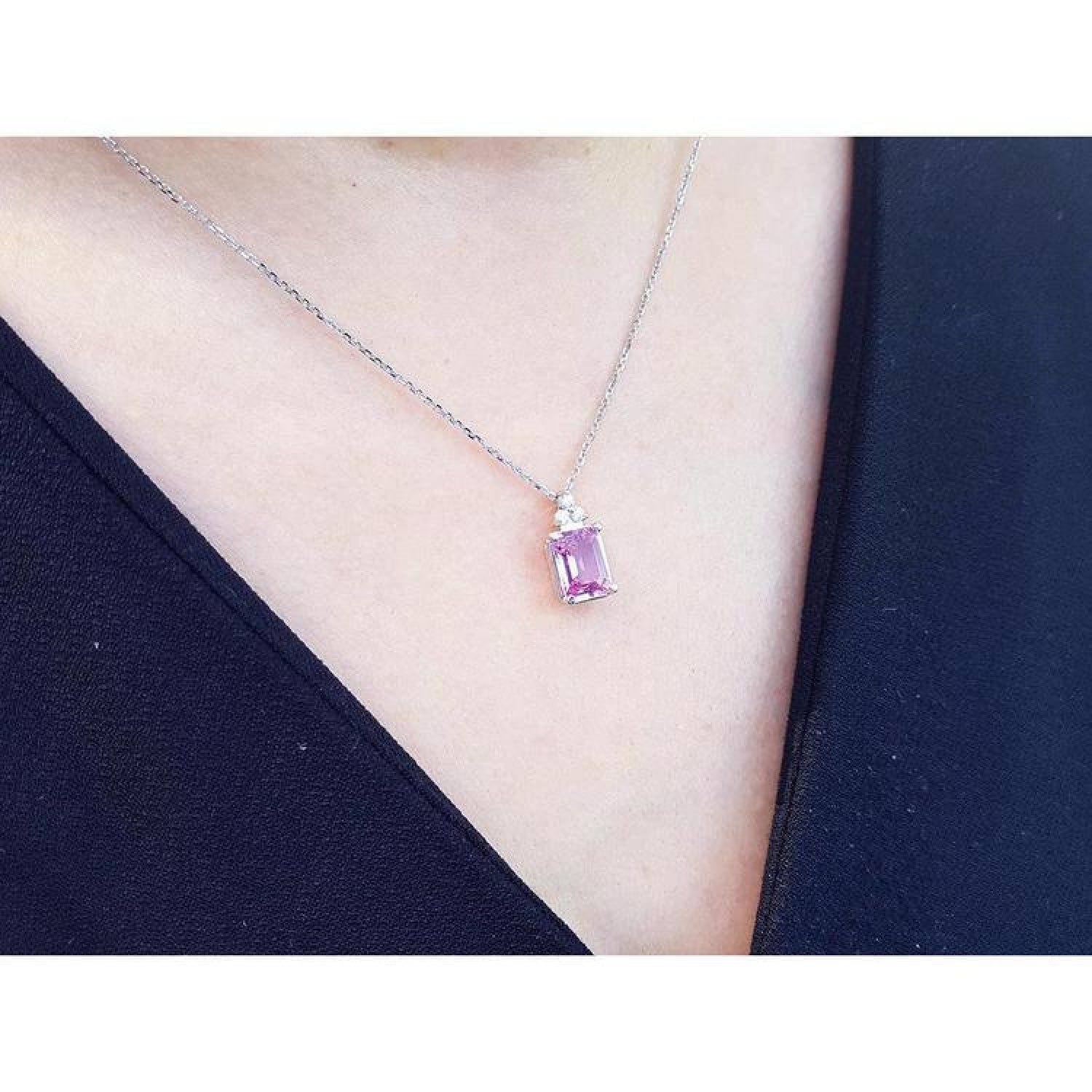 2.01 ct. natural pink sapphire emerald cut necklace in 14K white gold, worn on a person.