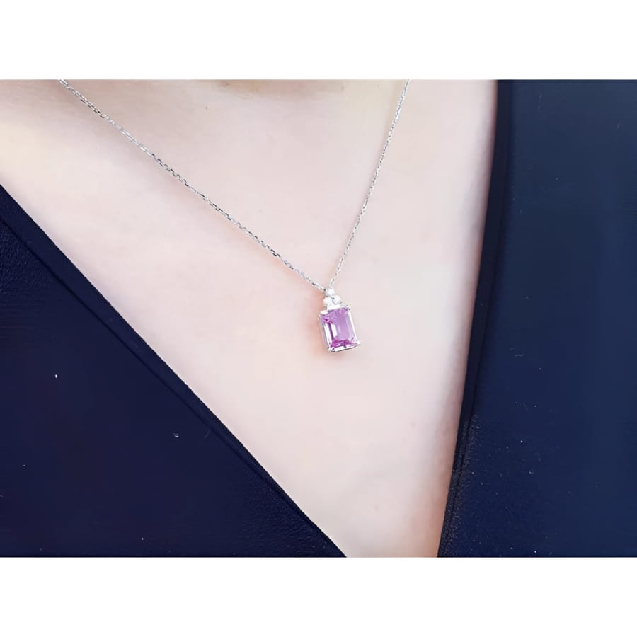 2.01 ct. natural pink sapphire emerald cut necklace in 14K white gold, worn on a person.
