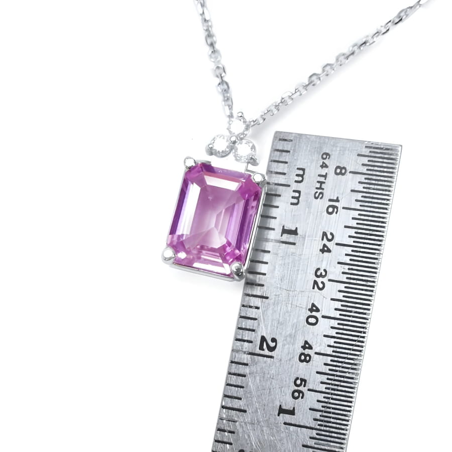 Pink sapphire emerald cut necklace in 14K white gold, shown with a ruler for scale.