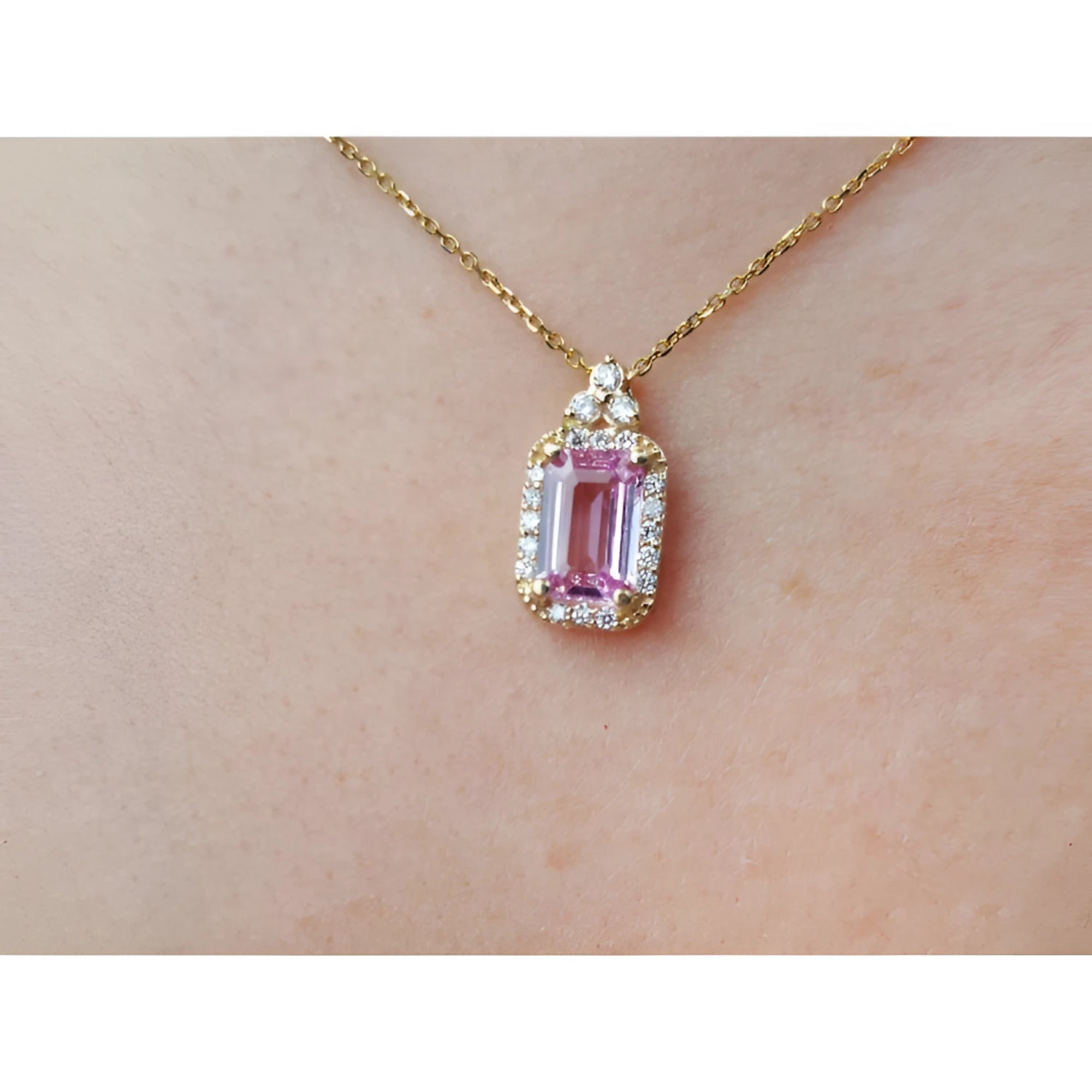 Natural pink sapphire and diamonds pendant necklace on a person's neck.