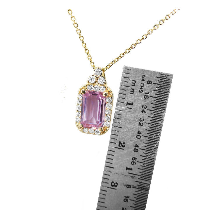 Pink sapphire necklace with gold chain next to a ruler for scale in 14k gold.
