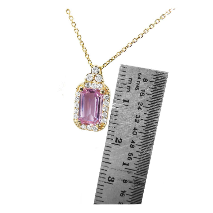Pink sapphire necklace with gold chain next to a ruler for scale in 14k gold.