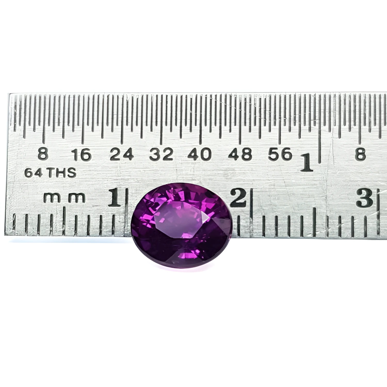 2.59 ct natural intense vivid purple-pink oval cut sapphire gemstone next to a ruler.