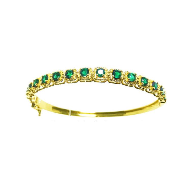 
A 14k gold bangle bracelet with round cut natural colombian emeralds brilliant cut sparkling bluish green color.