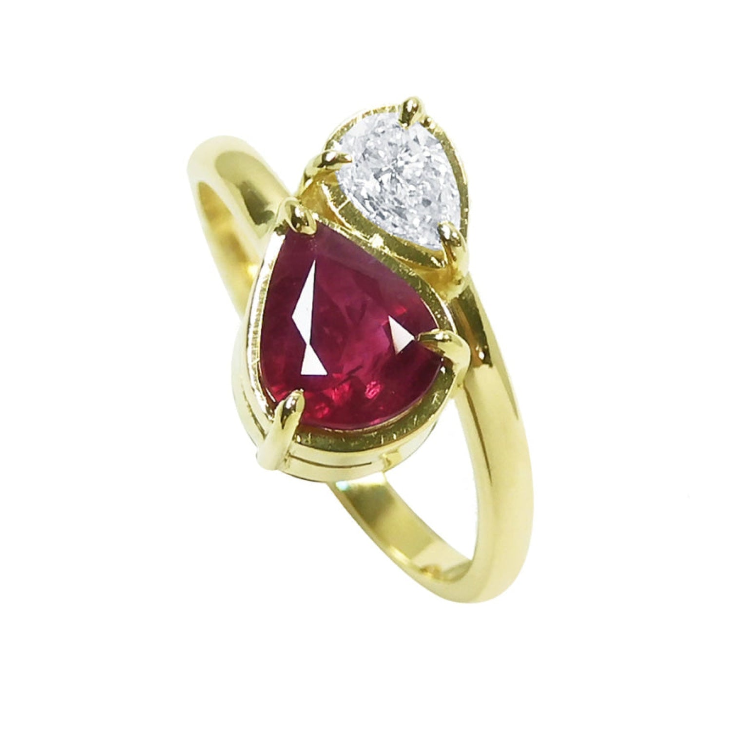 A You and Me 18k yellow gold ring featuring a pear-cut natural ruby and a smaller pear-cut clear diamond, in a toi et moi style.