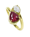 A You and Me 18k yellow gold ring featuring a pear-cut natural ruby and a smaller pear-cut clear diamond, in a toi et moi style.