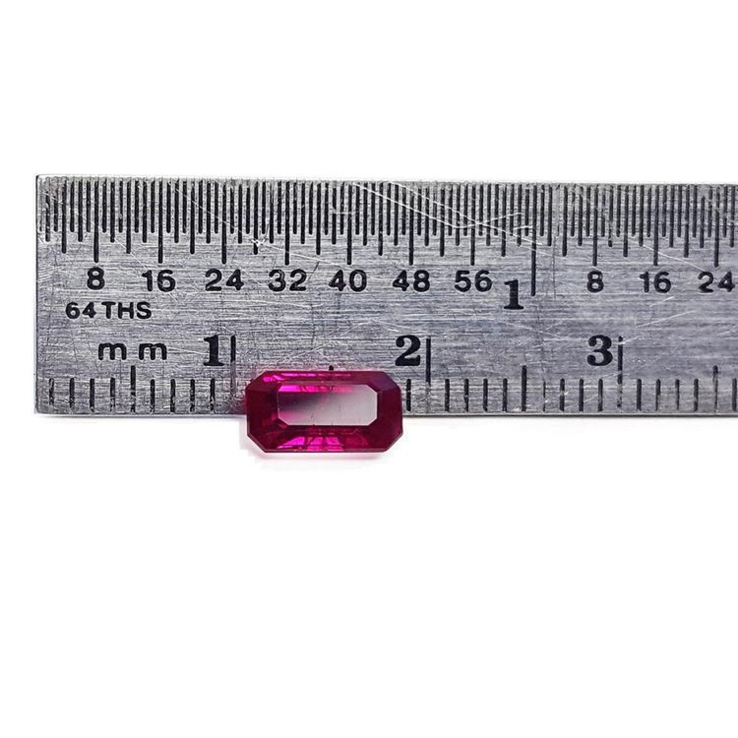 1.11 carat emerald cut natural ruby gemstone, deep red, displayed against a ruler.