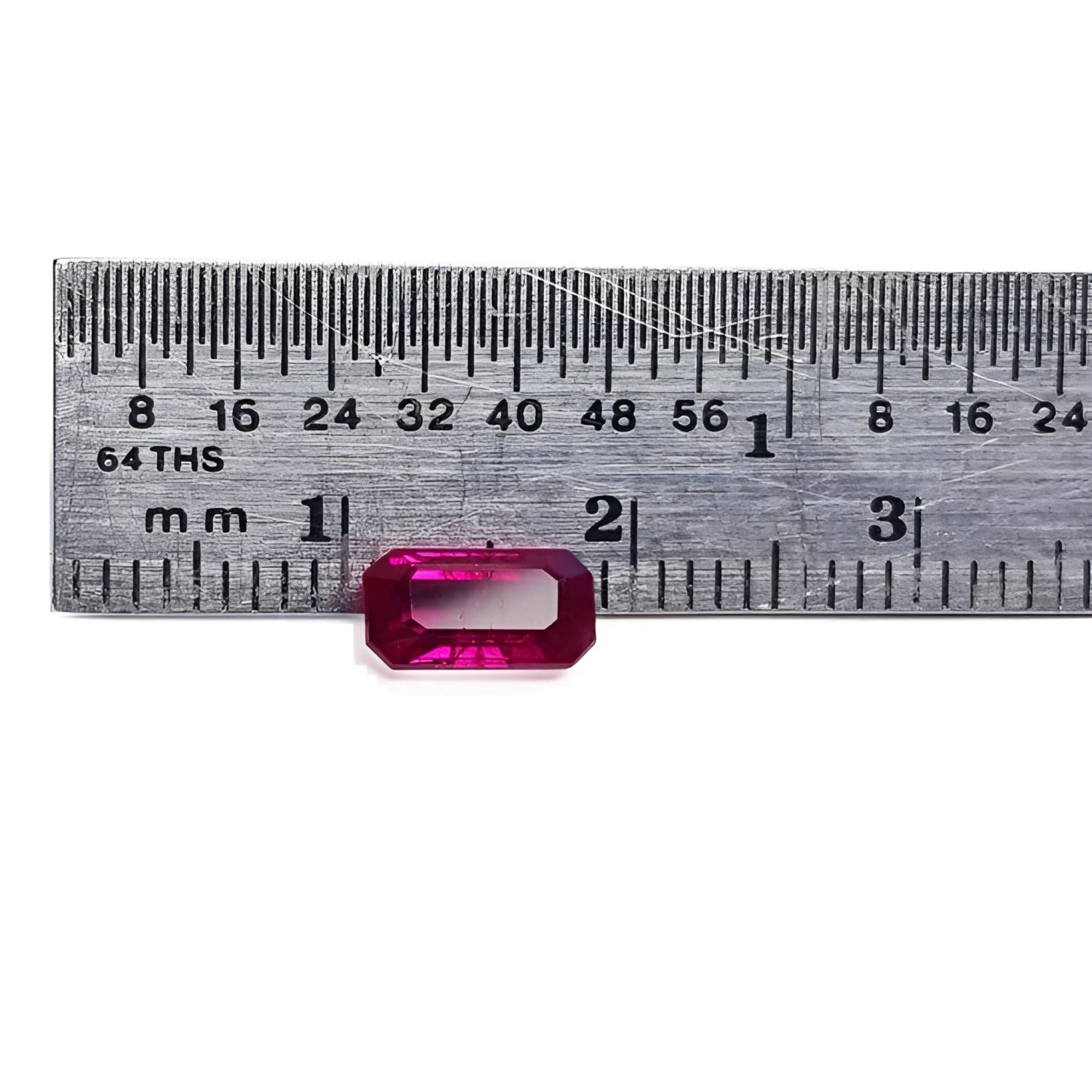 1.11 carat emerald cut natural ruby gemstone, deep red, displayed against a ruler.