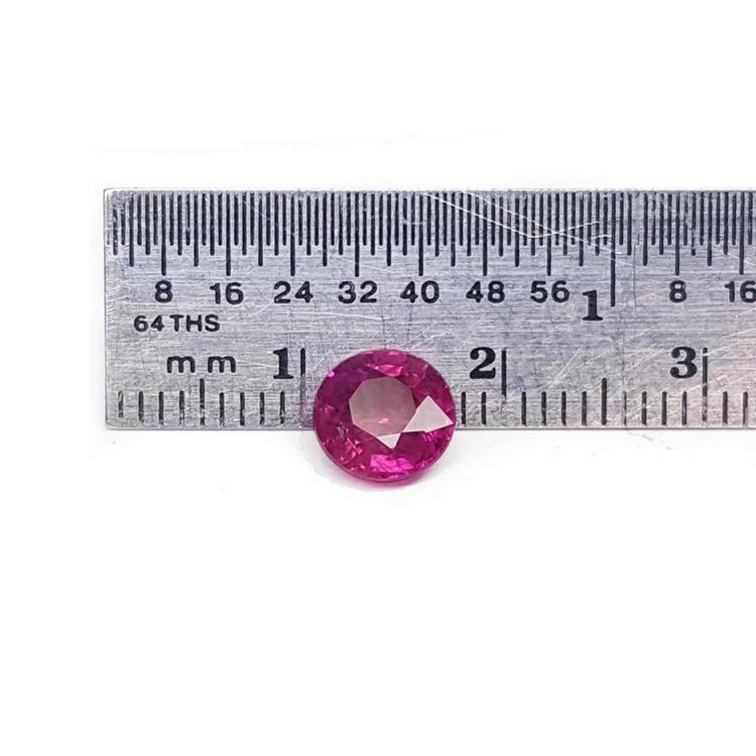 1.64 carat natural round cut ruby with vibrant medium red hue, shown next to a ruler for scale.