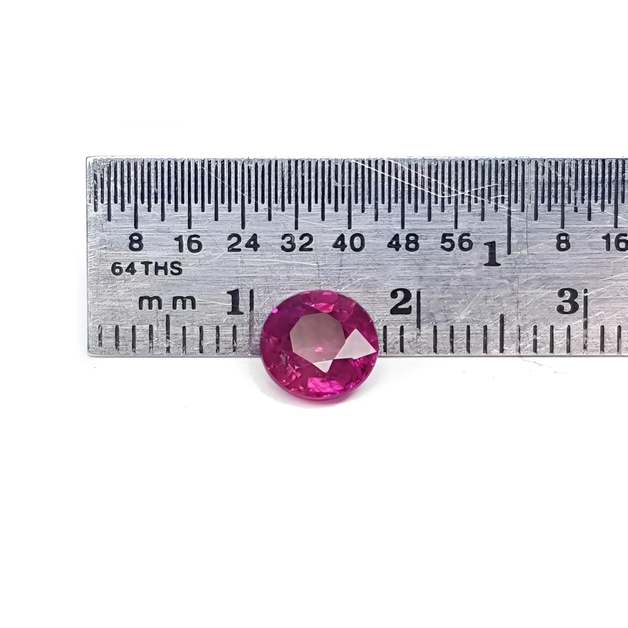 1.64 carat natural round cut ruby with vibrant medium red hue, shown next to a ruler for scale.