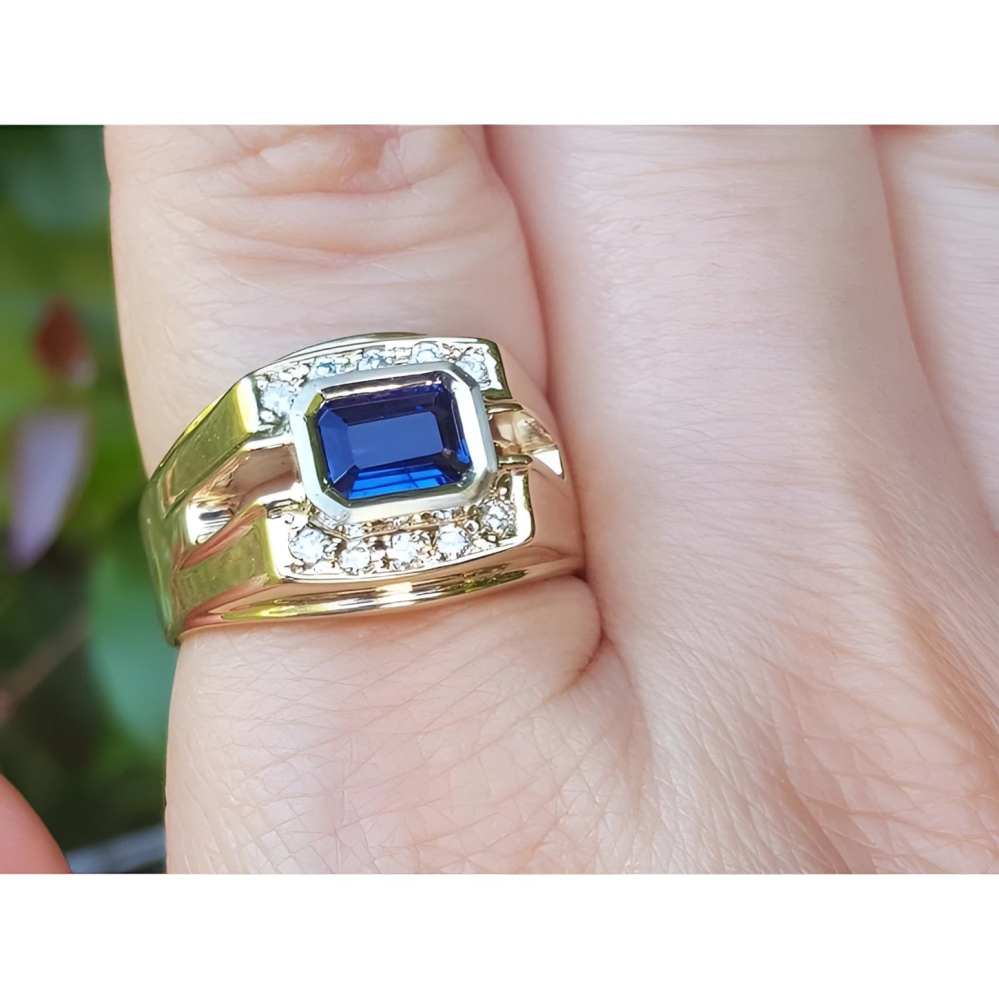 Gold ring with a blue natural sapphire and it is elegantly bordered on each side by a row of natural diamonds in 18k gold.