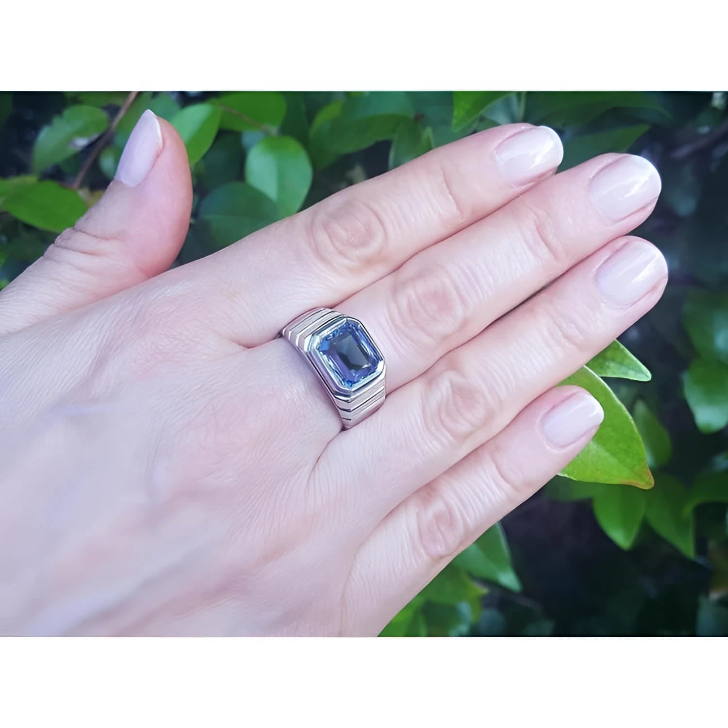 Men's 18K white gold ring with a 5.76 ct vivid blue emerald-cut sapphire in a bezel setting.