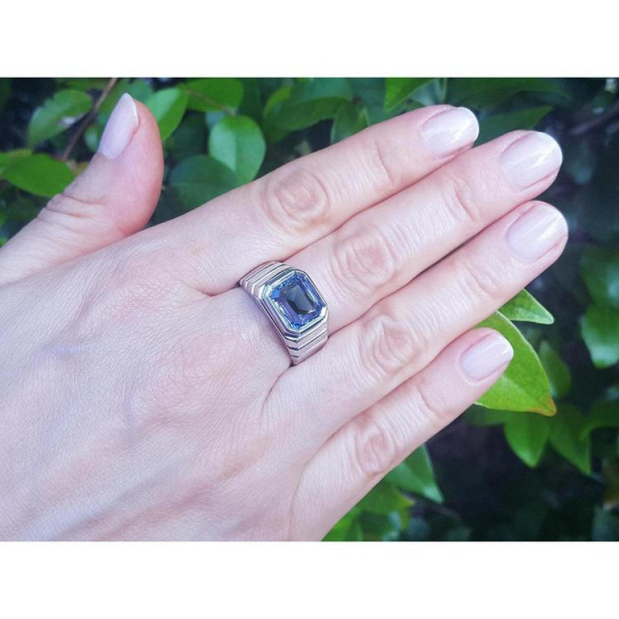 Men's 18K white gold ring with a 5.76 ct vivid blue emerald-cut sapphire in a bezel setting.