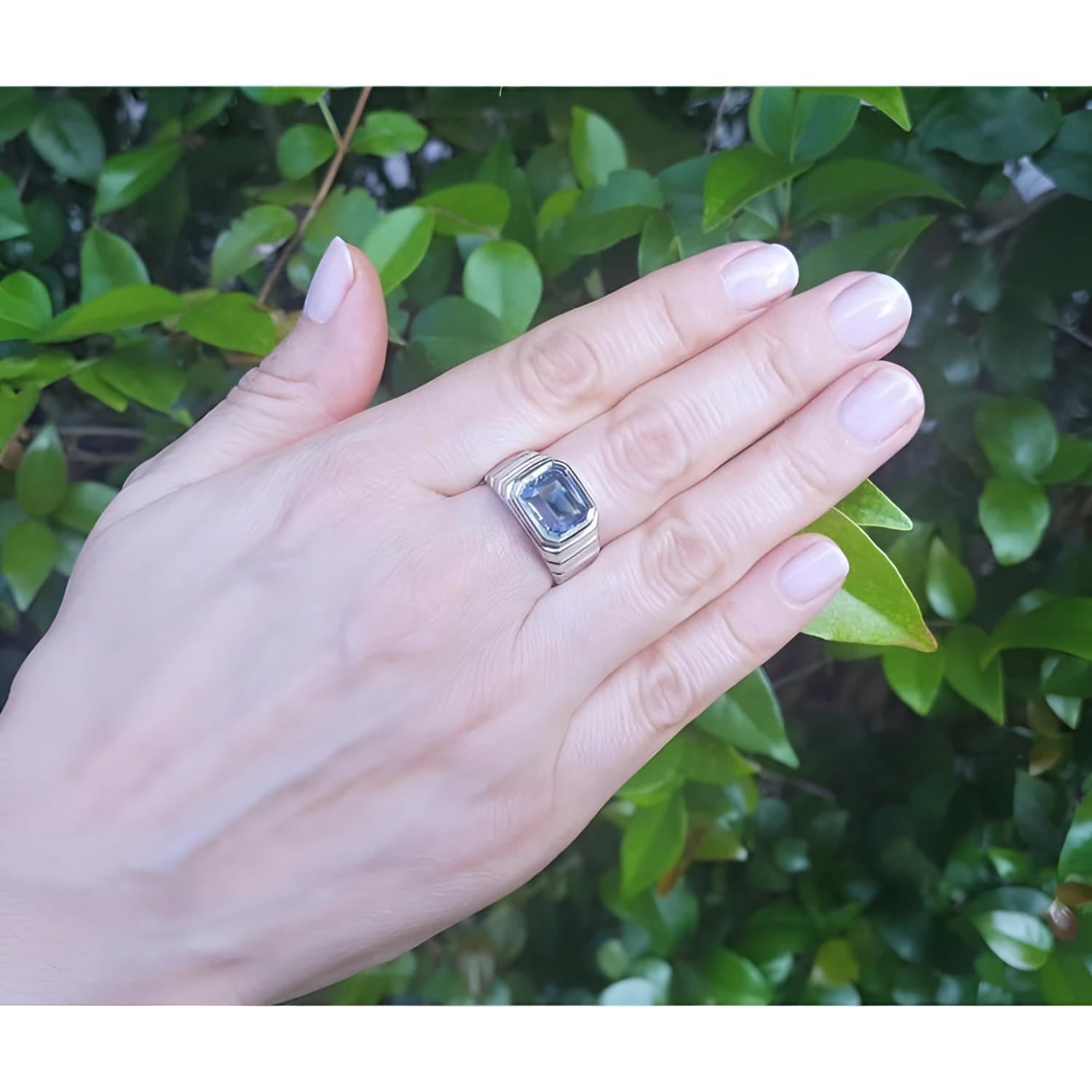 Men's 18K white gold ring with a bezel-set, emerald-cut 5.76 ct vivid blue sapphire.