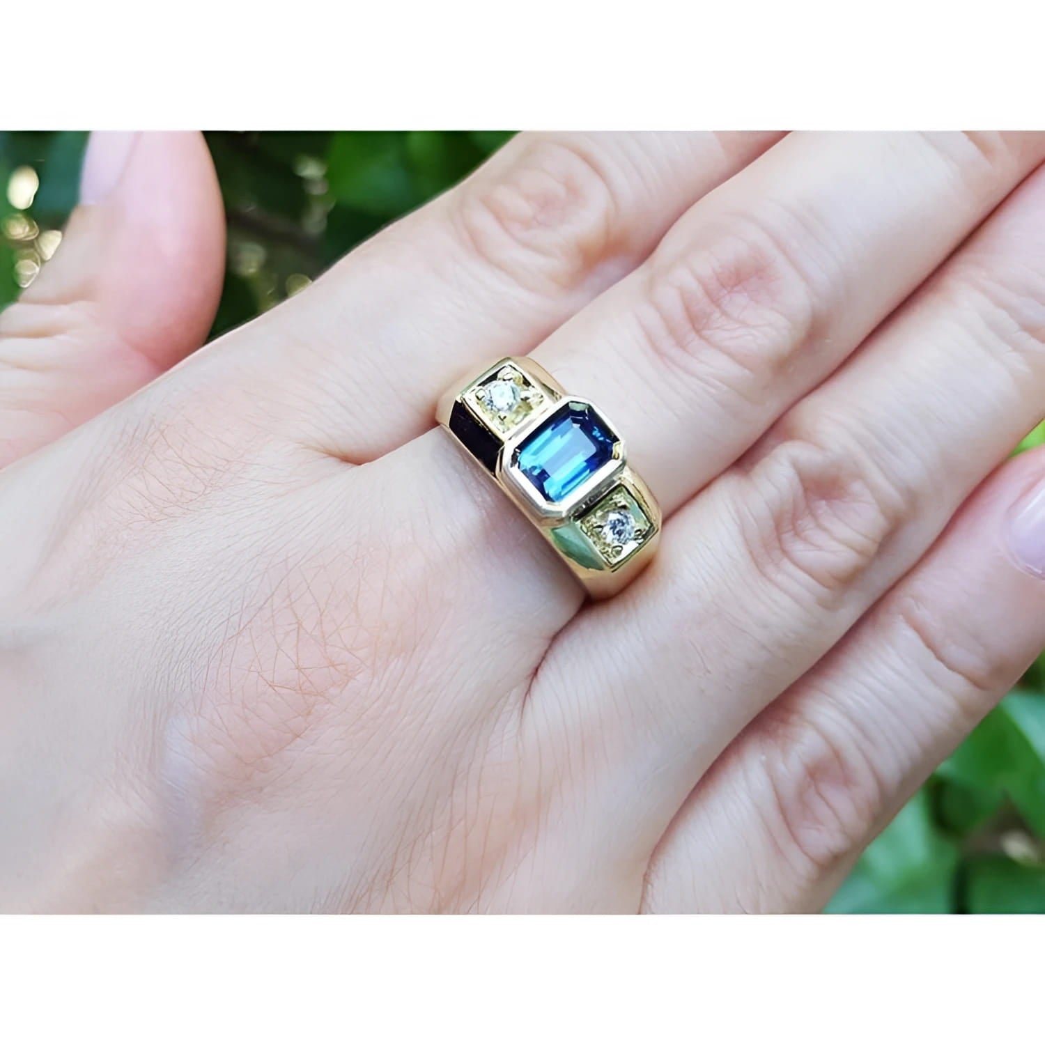 Men's 14K yellow gold ring with emerald cut blue sapphire and two round side diamonds.