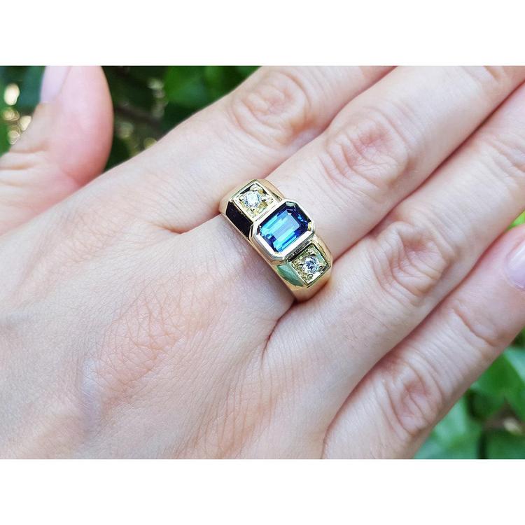 Men's 14K yellow gold ring with emerald cut blue sapphire and two round side diamonds.