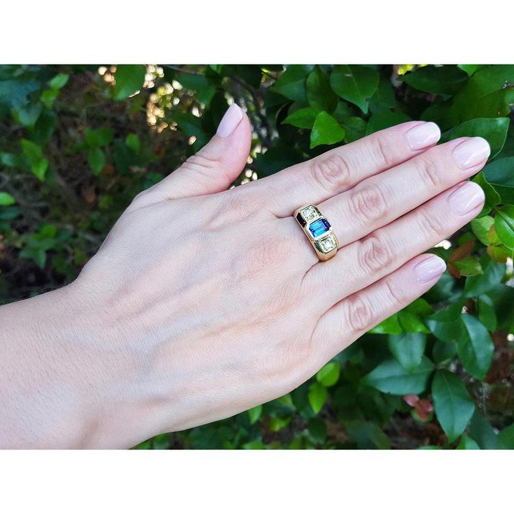 Men's 14K yellow gold ring with emerald cut blue sapphire and two round side diamonds.