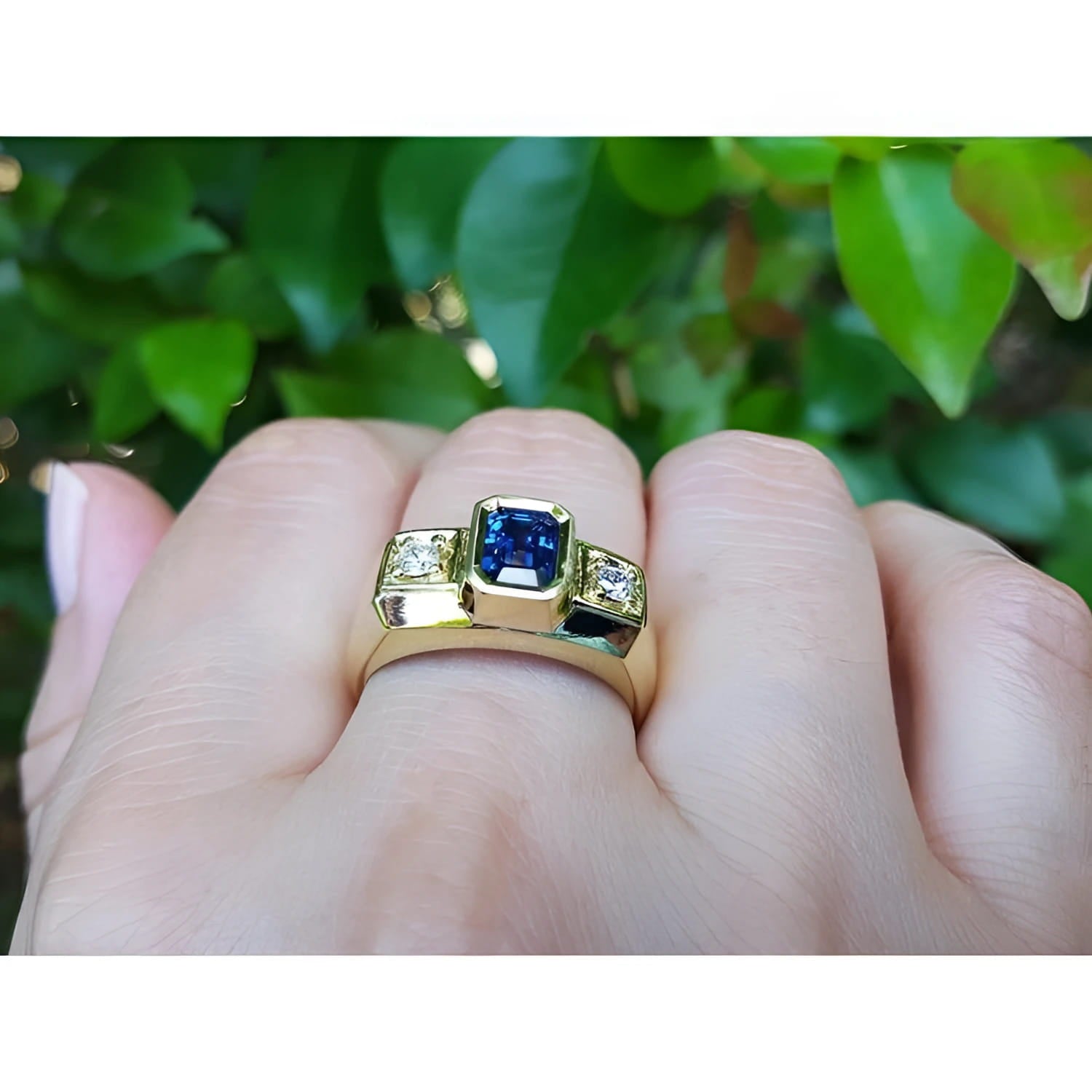 Men's 14K yellow gold ring with emerald cut blue sapphire and two round side diamonds.