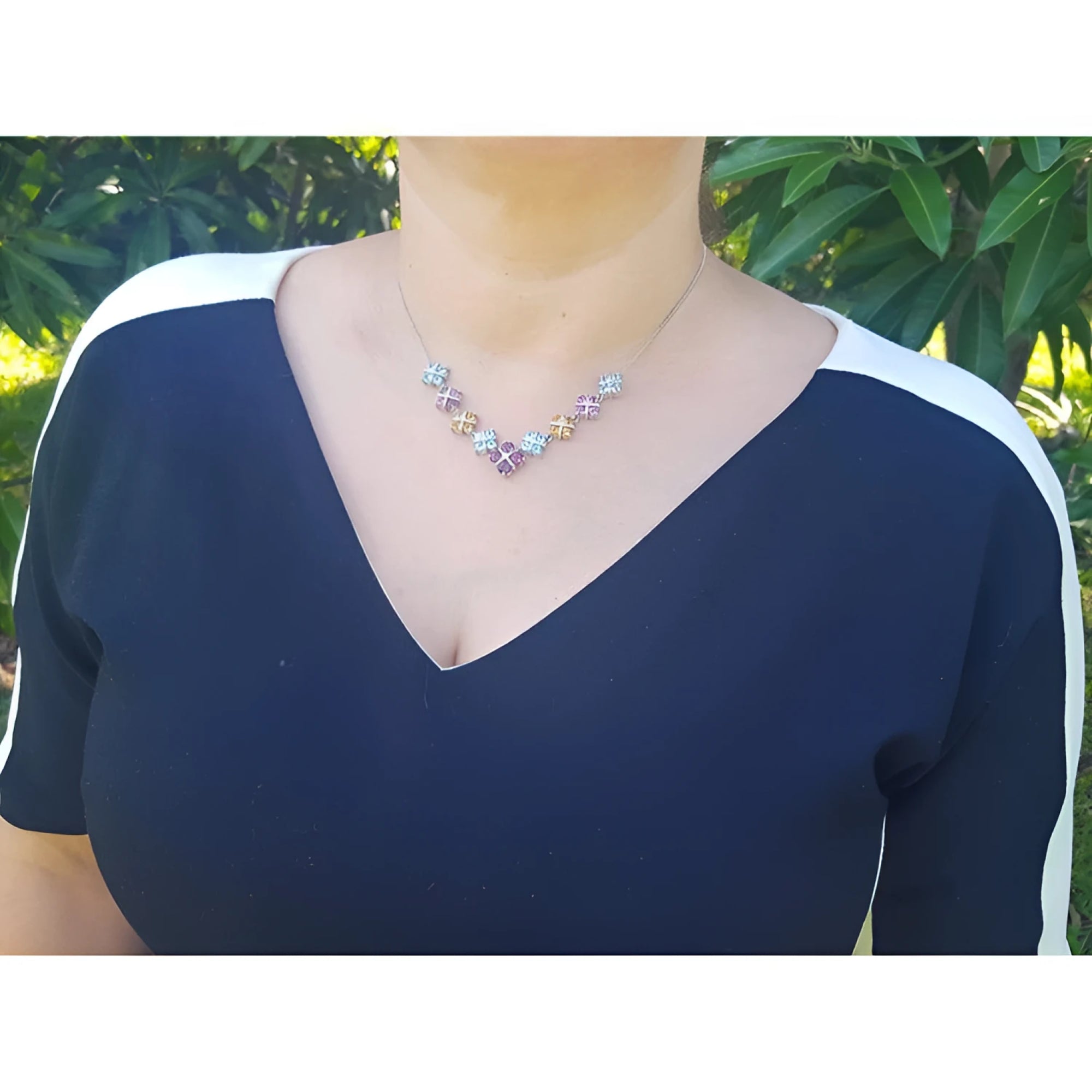 Woman wearing an 18K white gold necklace with tri-colored topaz X-cluster links.