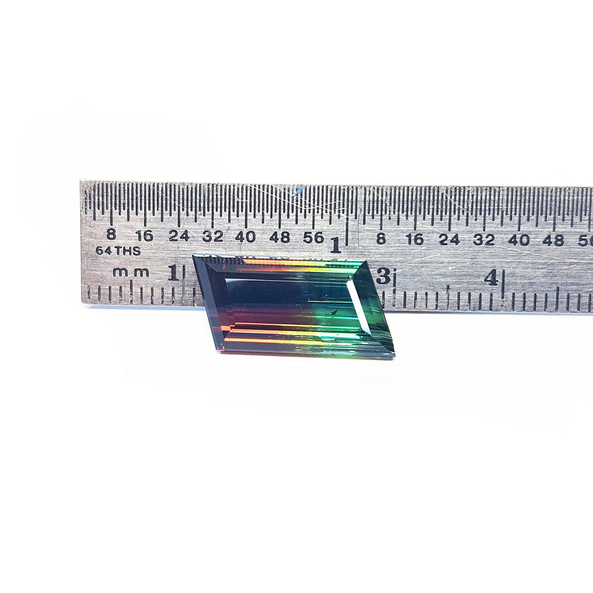 A Brazilian watermelon tourmaline next to a ruler on a white background.