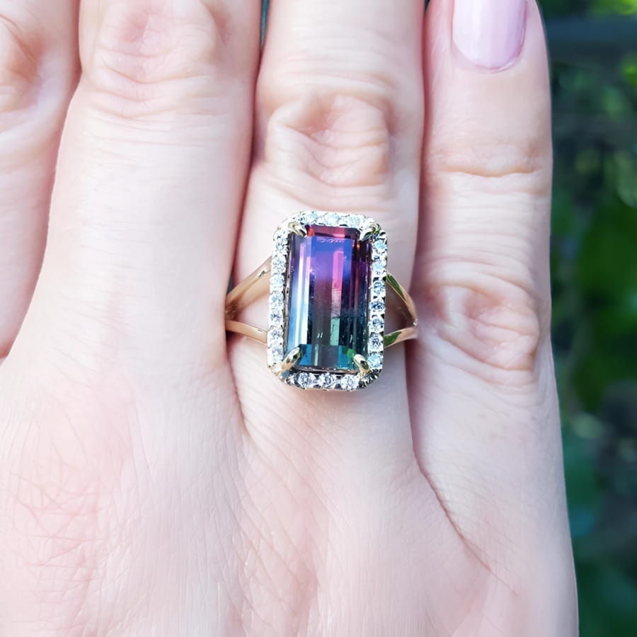 Women's 14K gold ring with a rectangular 5.60 ct. green and pink watermelon tourmaline, surrounded by diamonds.