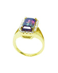 This natural watermelon tourmaline ring with a halo diamond, crafted in 14k yellow gold, is on a lateral profile view.