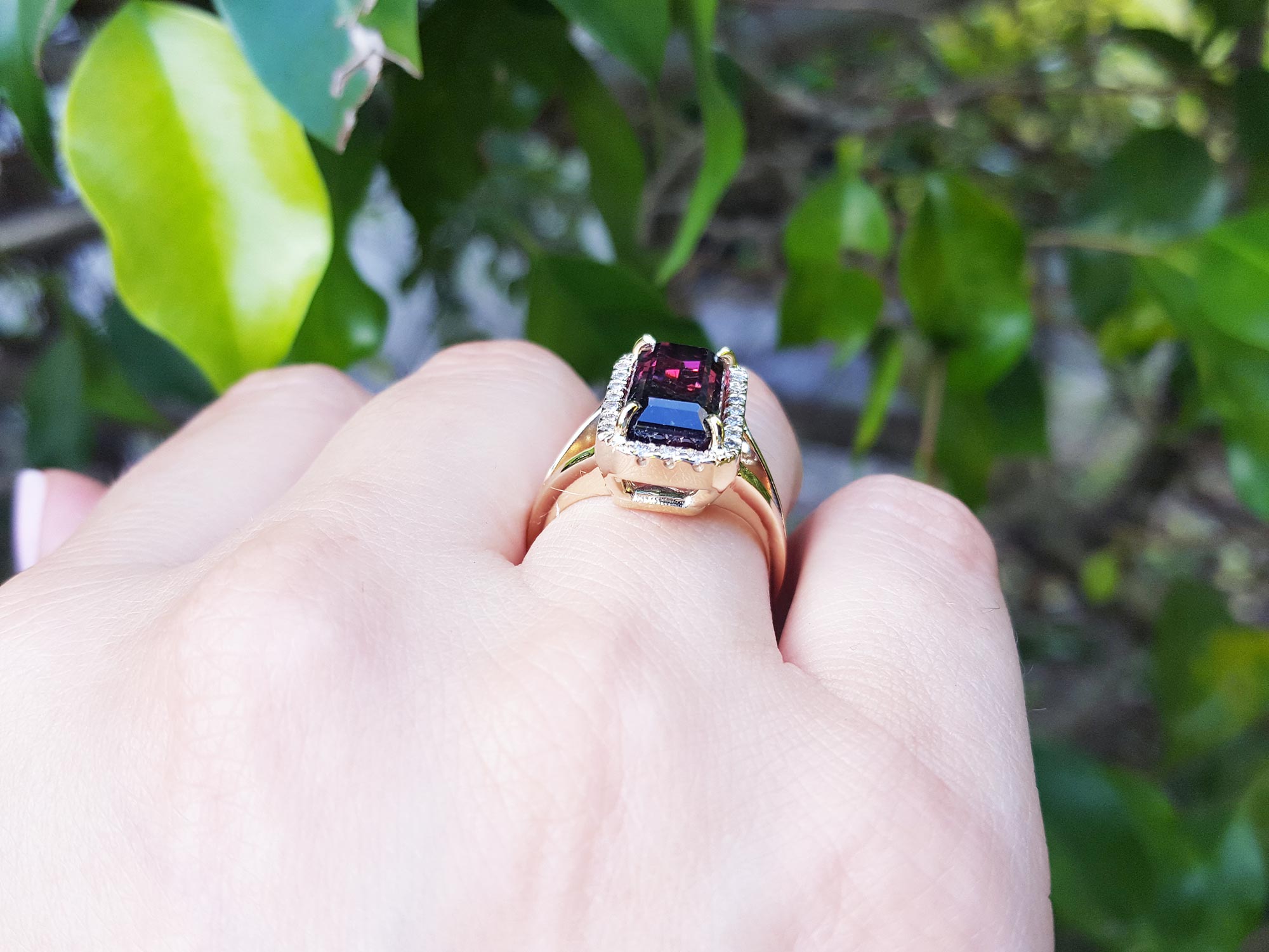 Downside profile view of a watermelon tourmaline ring being wear on a hand.