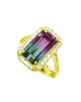 A natural watermelon tourmaline ring with a halo diamond, crafted in 14k yellow gold, tilted left side position top view.