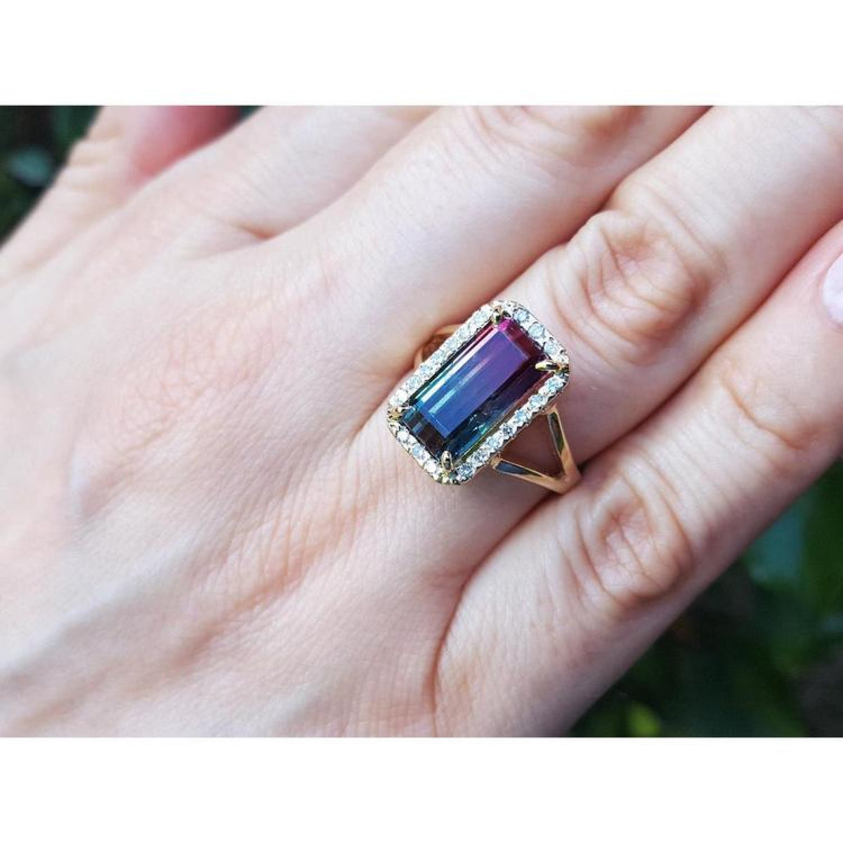 Watermelon tourmaline ring with green and pink rectangular gemstone, surrounded by diamonds on a 14K gold band.