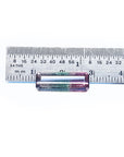 A rectangular natural watermelon tourmaline next to a ruler on a white background.