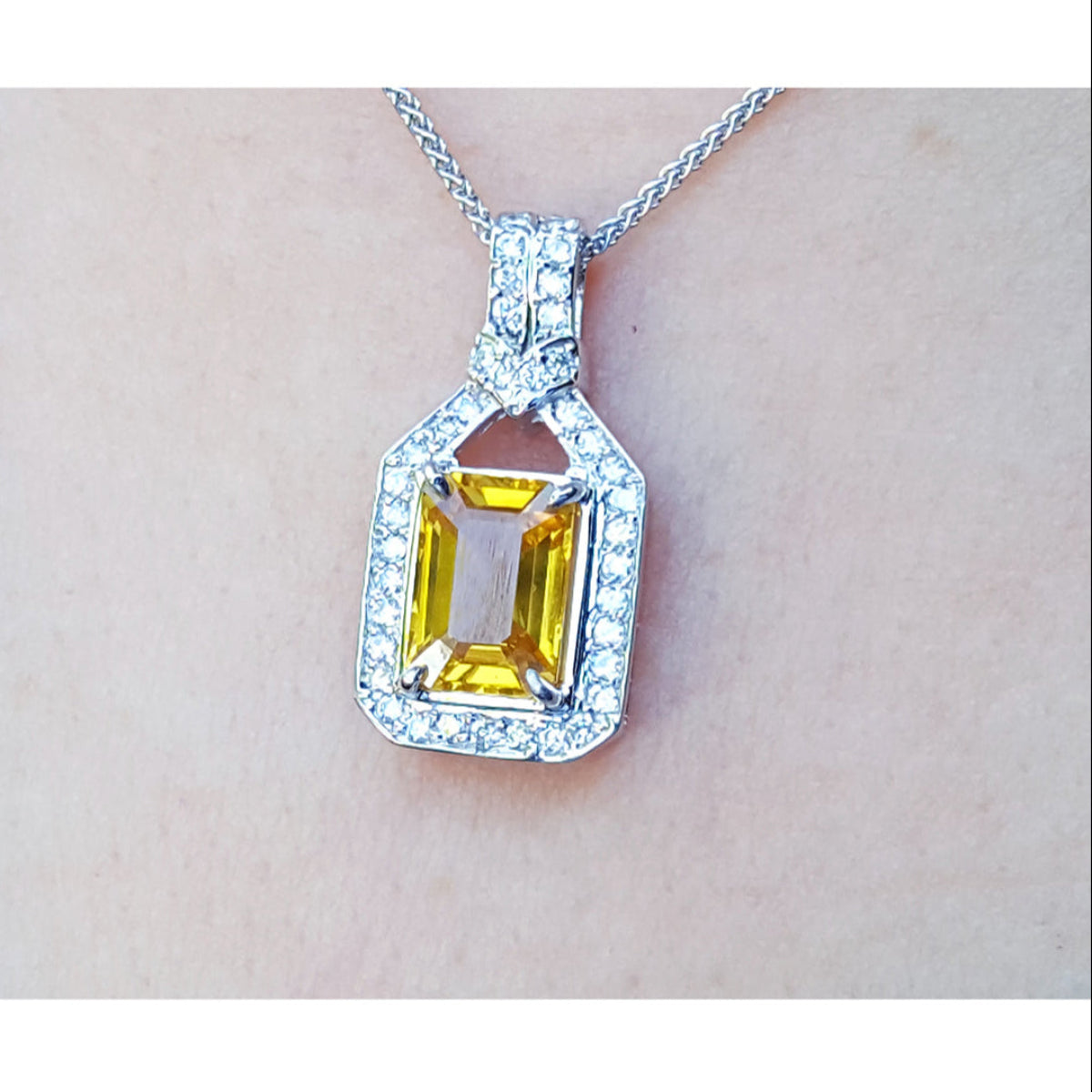 Hanging on a woman&#39;s neck a natural yellow sapphire pendant necklace halo diamond 18k white gold