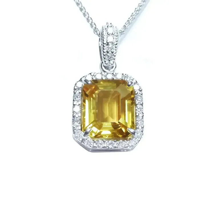 Natural yellow sapphire pendant showcasing a vibrant medium-light hue halo diamonds handcrafted in 18k white gold.