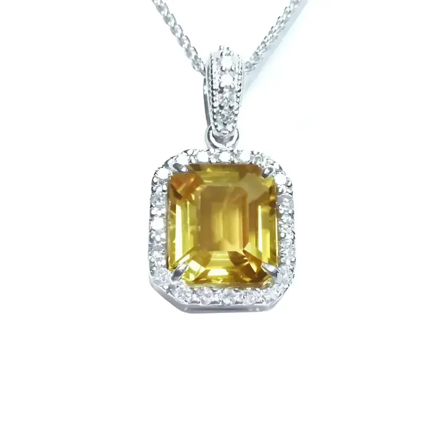 Natural yellow sapphire pendant showcasing a vibrant medium-light hue halo diamonds handcrafted in 18k white gold.