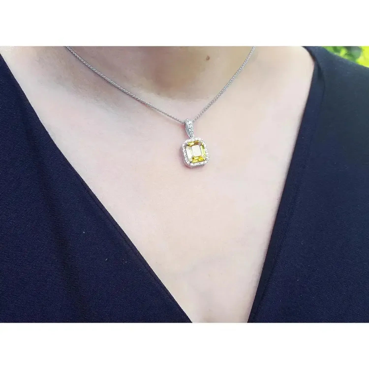 Emerald cut 6.01 ct. natural yellow sapphire pendant with diamond halo on 18K white gold chain.