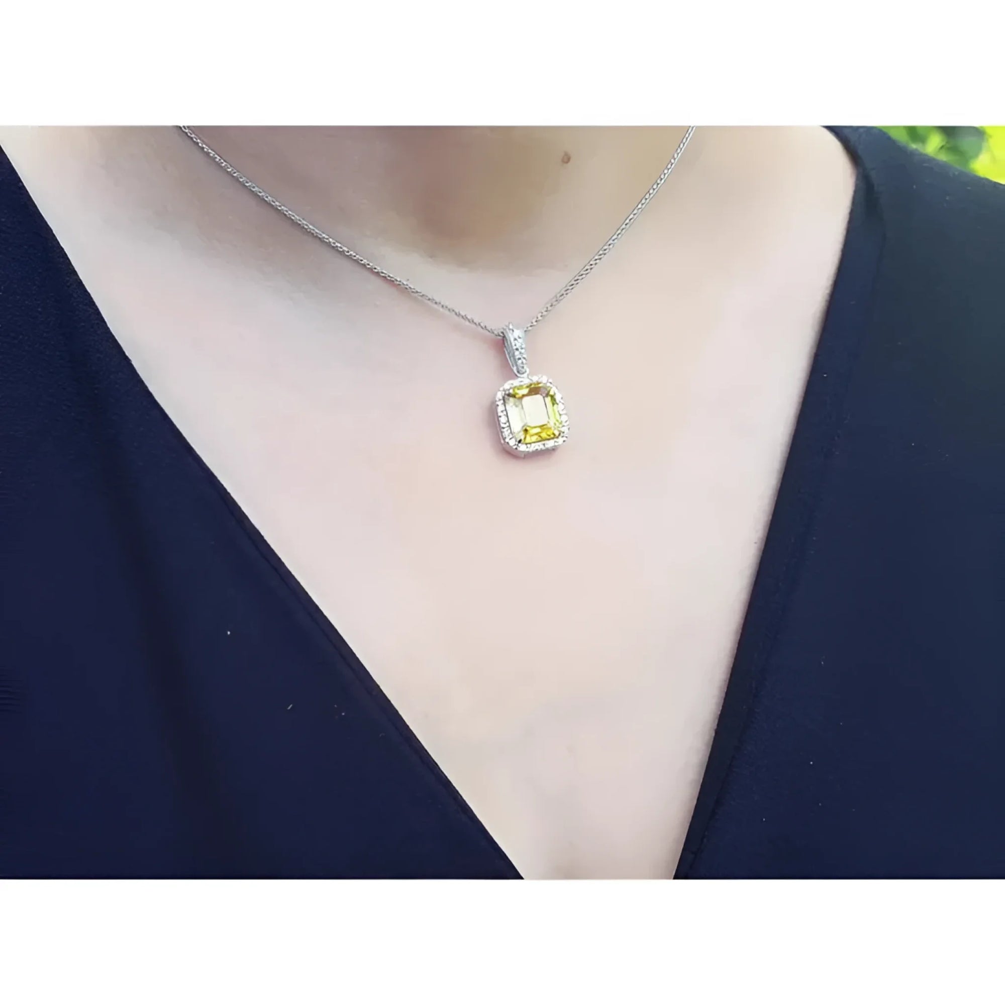 Emerald cut 6.01 ct. natural yellow sapphire pendant with diamond halo on 18K white gold chain.