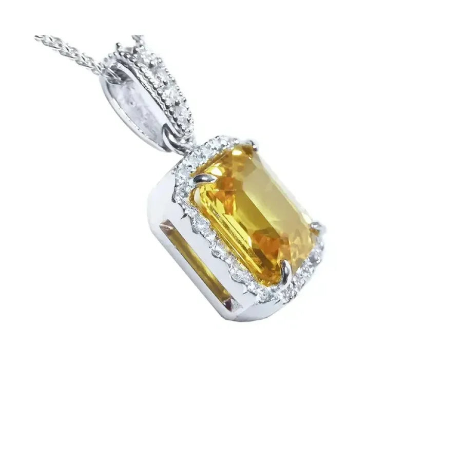 Emerald cut 6.01 ct. yellow sapphire pendant with diamond halo in 18K white gold.