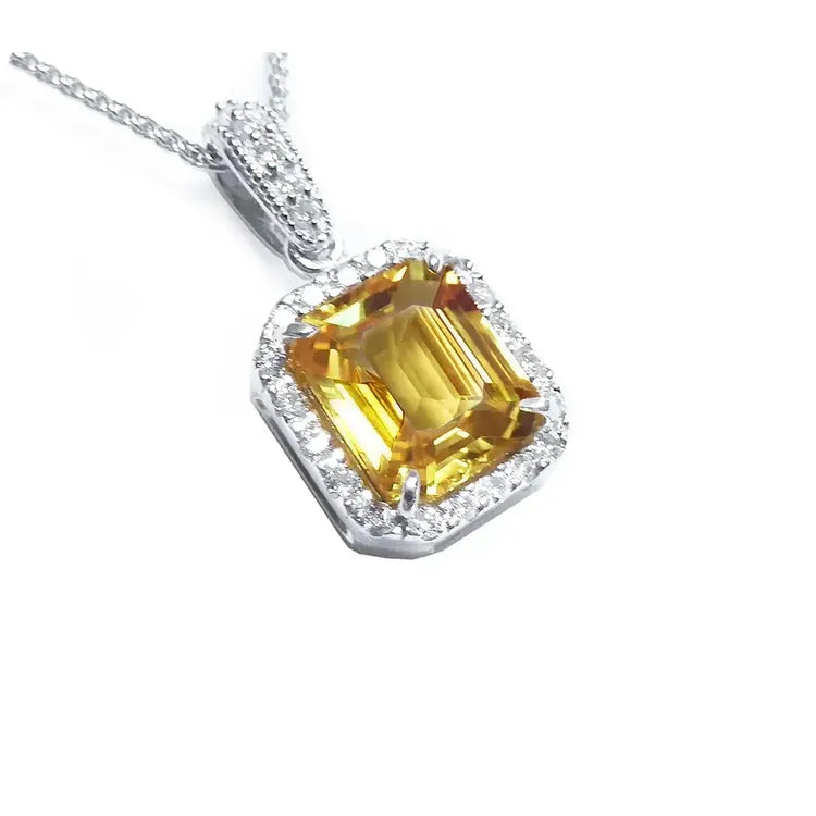 Right side, top view of a natural yellow sapphire pendant halo diamonds handcrafted in 18k white gold