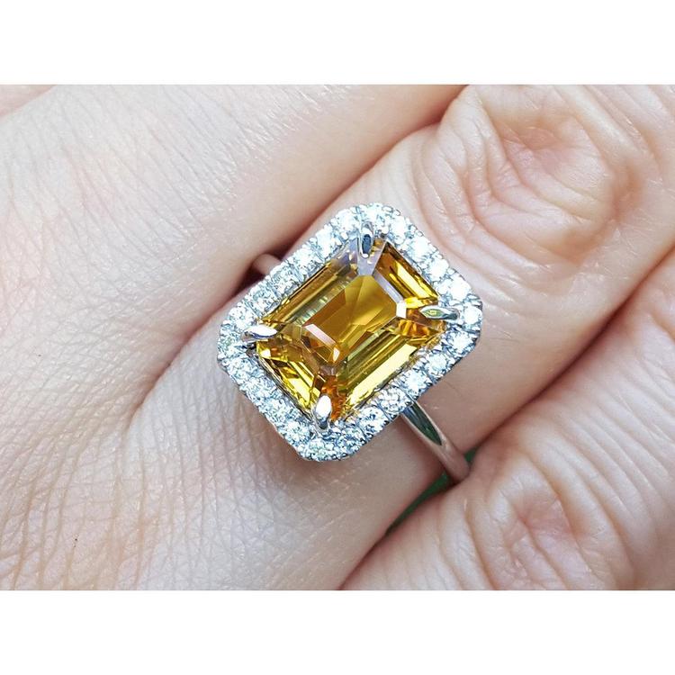 14k white gold Ring with a yellow natural sapphire emerald cut and diamond accents on a finger